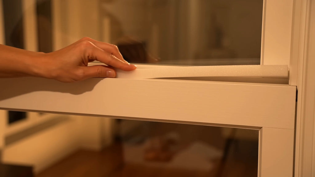 Pressing the SnapSeal peel-and-press strip firmly onto the window frame